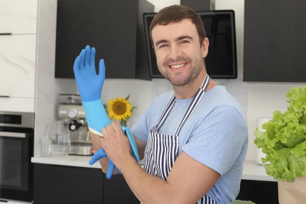 Portret Przystojnego Młodzieńca Zakładającego Gumowe Rękawiczki Sprzątania Kuchni — Zdjęcie stockowe