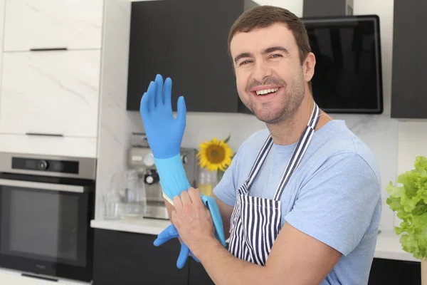 台所で掃除するためのゴム手袋をはめたハンサムな若い男の肖像画 — ストック写真
