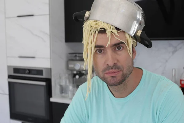 Portret Przystojnego Młodzieńca Garnkiem Spaghetti Głowie Kuchni — Zdjęcie stockowe