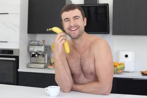 Πορτρέτο Του Όμορφου Γυμνόστηθη Νεαρός Άνδρας Κρατώντας Μπανάνα Στην Κουζίνα — Φωτογραφία Αρχείου