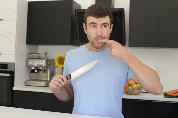 ハンサムな若い男の肖像画は台所でナイフで指を切り — ストック写真