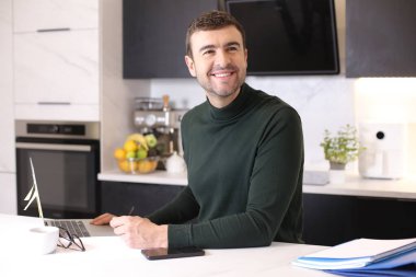 Mutfaktaki yakışıklı genç adamın portresi.