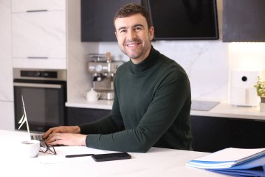 Mutfaktaki yakışıklı genç adamın portresi.