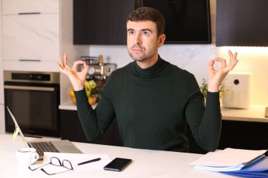 Bilgisayarlı yakışıklı bir gencin portresi mutfaktan çalışıyor.