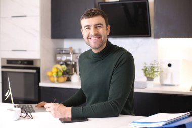 Mutfaktaki yakışıklı genç adamın portresi.