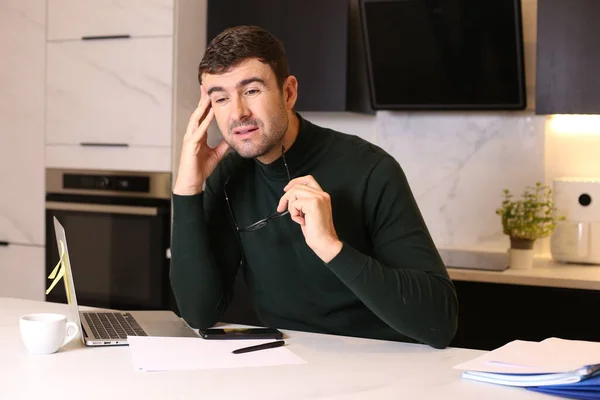 stock image portrait of handsome young man with laptop working from home at kitchen