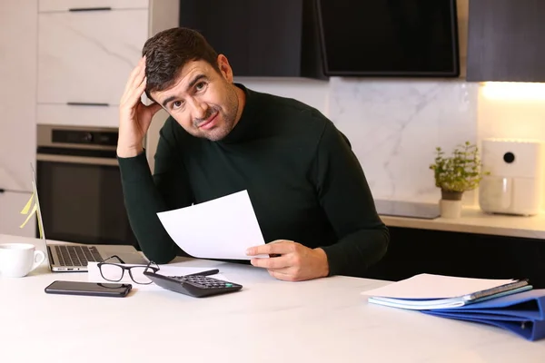 stock image portrait of handsome young man working from home with laptop at kitchen