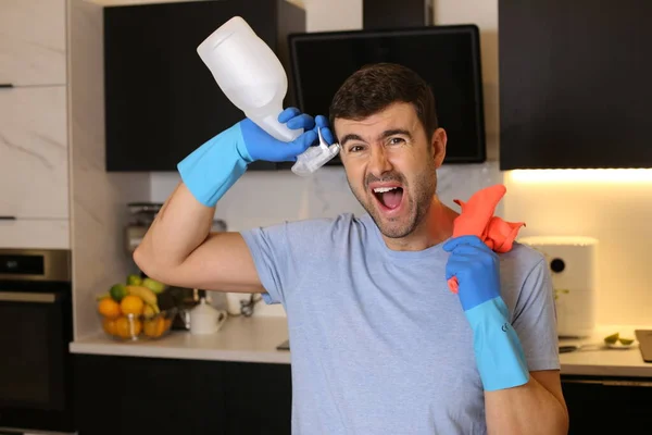 台所で掃除用品を持っているハンサムな若い男の肖像画 — ストック写真