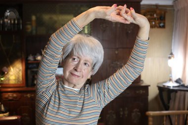 close-up portrait of mature woman stretching at home