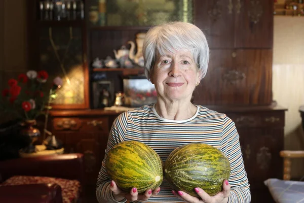 close-up portrait of mature woman with melons at home