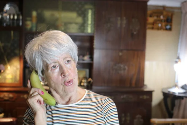 close-up portrait of mature woman with banana at home