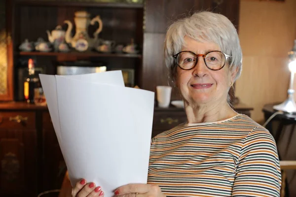 close-up portrait of mature woman with papers at home