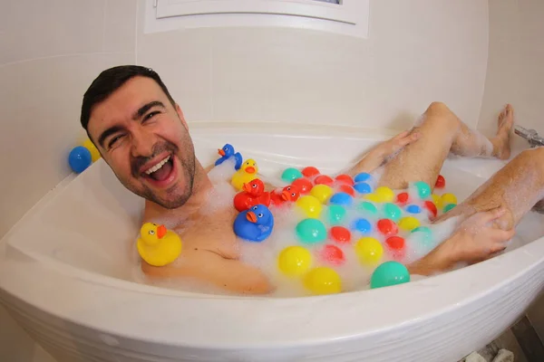 Широкоугольный Снимок Счастливого Молодого Человека Резиновыми Утятами Шариками Веселящихся Ванной — стоковое фото