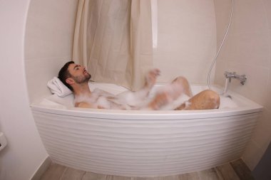 wide angle shot of handsome young man in bath