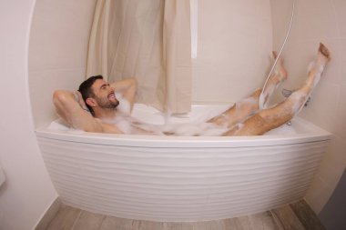 wide angle shot of handsome young man in bath