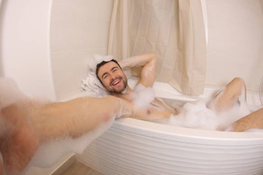 wide angle shot of handsome young man talking selfie in bath