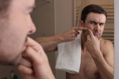 Banyoda aynanın önünde sivilcelerini sıkan yakışıklı bir gencin portresi.