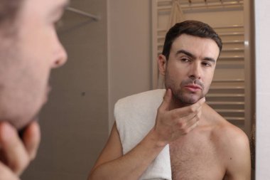 Banyoda aynanın önünde genç bir adamın portresi.