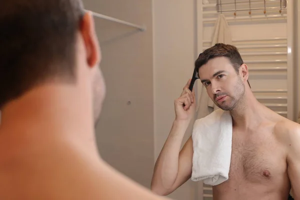 Porträtt Stilig Ung Man Borsta Håret Framför Spegeln Badrummet — Stockfoto