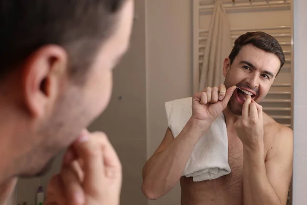 Banyoda Aynanın Önünde Diş Ipi Kullanan Yakışıklı Bir Gencin Portresi — Stok fotoğraf
