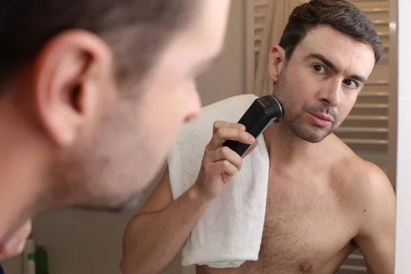Retrato Belo Jovem Barbeando Barba Com Barbeador Elétrico Frente Espelho — Fotografia de Stock