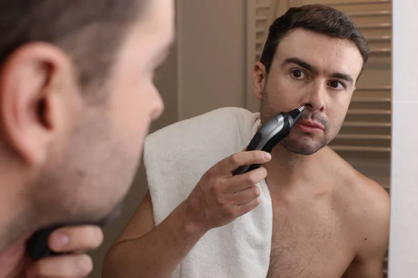 年轻英俊男子在浴室镜子前剪鼻毛的肖像 — 图库照片