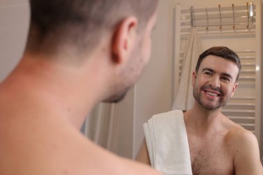 Banyoda aynanın önünde genç bir adamın portresi.