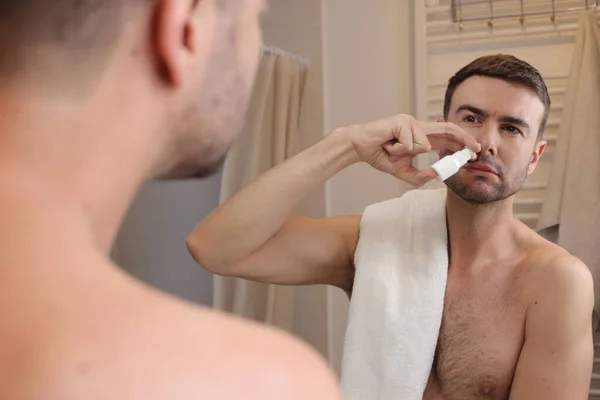 Портрет Красивого Молодого Человека Распыляющего Нос Перед Зеркалом Ванной Комнате — стоковое фото