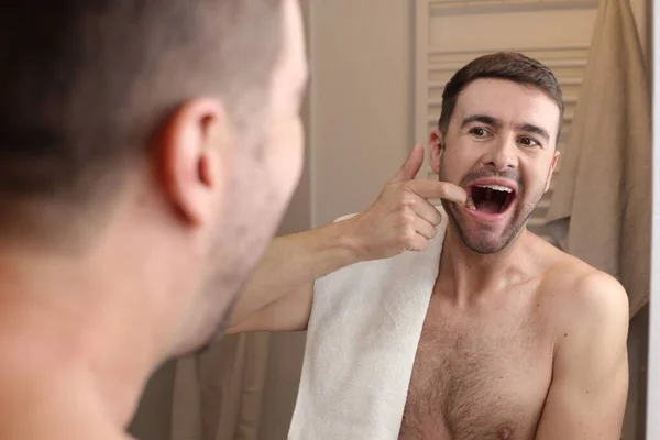 Muotokuva Komea Nuori Mies Tarkistaa Hampaansa Peilin Edessä Kylpyhuoneessa — kuvapankkivalokuva