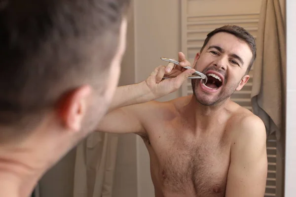 Potret Pemuda Tampan Menarik Keluar Giginya Depan Cermin Kamar Mandi — Stok Foto