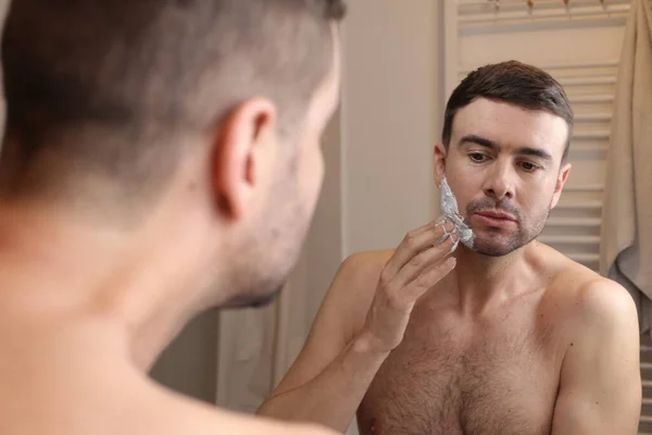 Porträtt Stilig Ung Man Tillämpa Raklödder Framför Spegeln Badrummet — Stockfoto