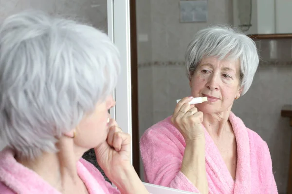 Yetişkin Bir Kadının Banyoda Aynanın Önünde Dudak Kremi Sürerken Yakın — Stok fotoğraf