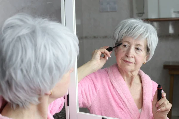 stock image close-up portrait of mature woman doing makeup in front of mirror in bathroom