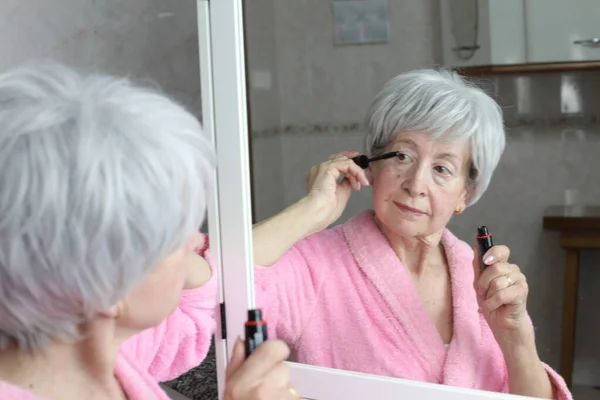 stock image close-up portrait of mature woman doing makeup in front of mirror in bathroom