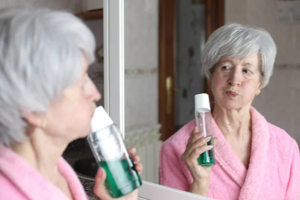 Närbild Porträtt Mogen Kvinna Med Flaska Munvatten Framför Spegeln Badrummet — Stockfoto