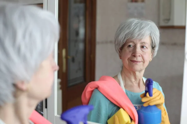 stock image close-up portrait of mature woman with cleaning supplies in front of mirror in bathroom