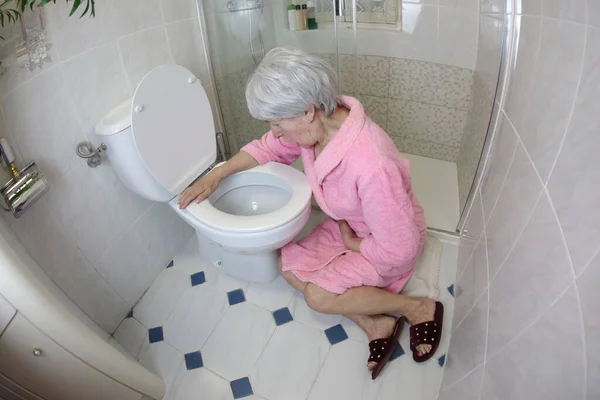 大角度拍摄的老年妇女坐在厕所附近 食物中毒 — 图库照片