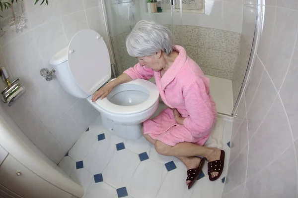 大角度拍摄的老年妇女坐在厕所附近 食物中毒 — 图库照片