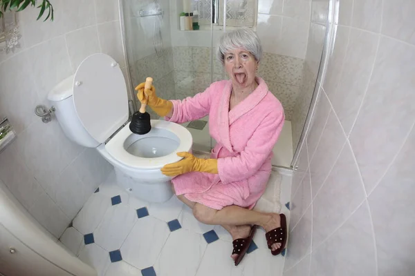 老年妇女清洁厕所的广角镜头 — 图库照片