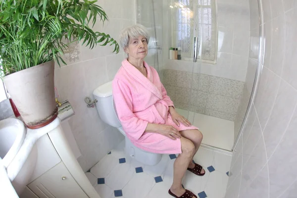 トイレに座っている先輩女性の広角撮影 — ストック写真