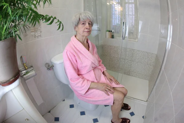 トイレに座っている先輩女性の広角撮影 — ストック写真