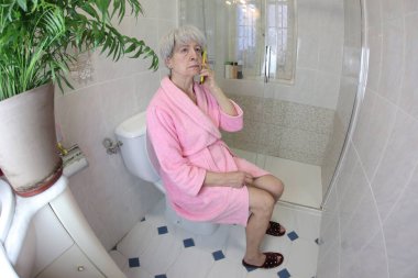 Son sınıf öğrencisinin tuvalette telefonla konuşurken geniş açılı görüntüsü.