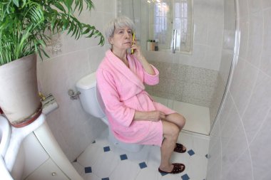 Son sınıf öğrencisinin tuvalette telefonla konuşurken geniş açılı görüntüsü.