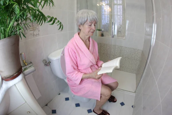 Wide Angle Shot Senior Woman Reading Book Toilet — Stock Photo, Image