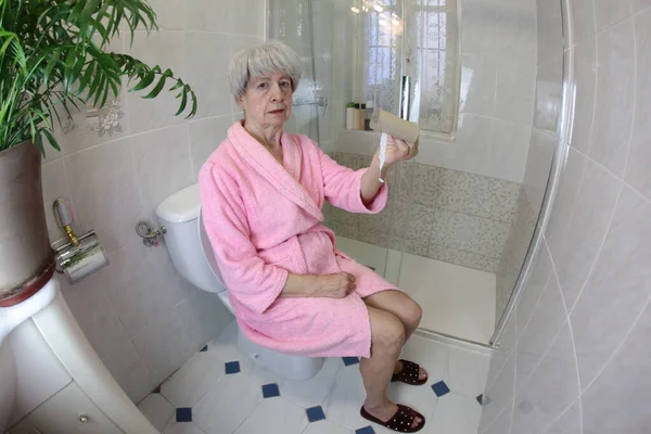 Vidvinkel Skott Senior Kvinna Med Tom Toalettpapper Rulle Sitter Toaletten — Stockfoto