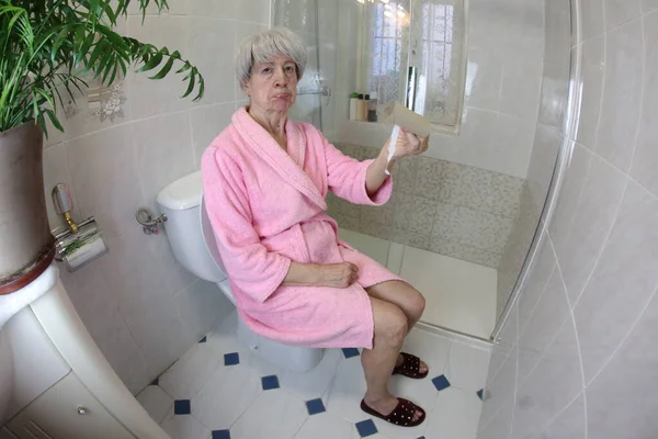 Weitwinkelaufnahme Einer Seniorin Mit Leerer Toilettenpapierrolle Der Toilette — Stockfoto