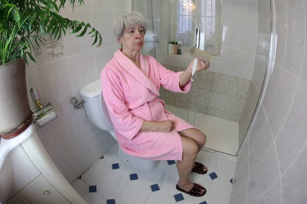 Широкоугольный Снимок Пожилой Женщины Пустым Рулоном Туалетной Бумаги Сидящей Туалете — стоковое фото