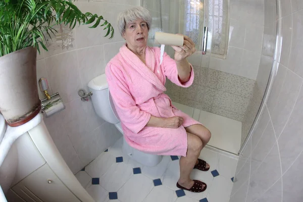 Широкоугольный Снимок Пожилой Женщины Пустым Рулоном Туалетной Бумаги Сидящей Туалете — стоковое фото