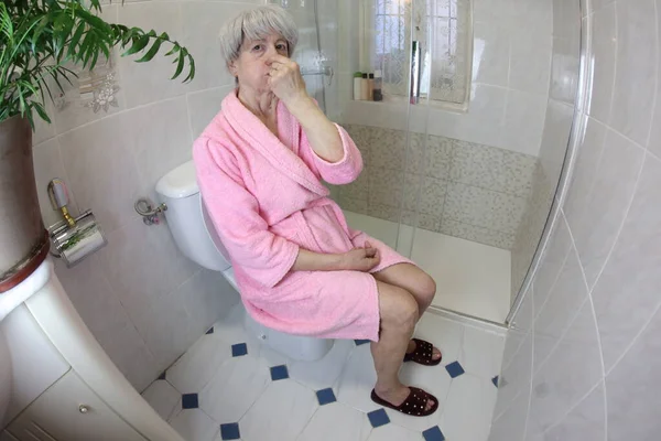 Szeroki Kąt Strzał Starszej Kobiety Zakrywa Nos Siedząc Toalecie — Zdjęcie stockowe