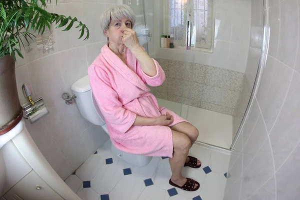 Yaşlı Bir Kadının Tuvalette Otururken Burnunu Kapattığı Geniş Açılı Bir — Stok fotoğraf